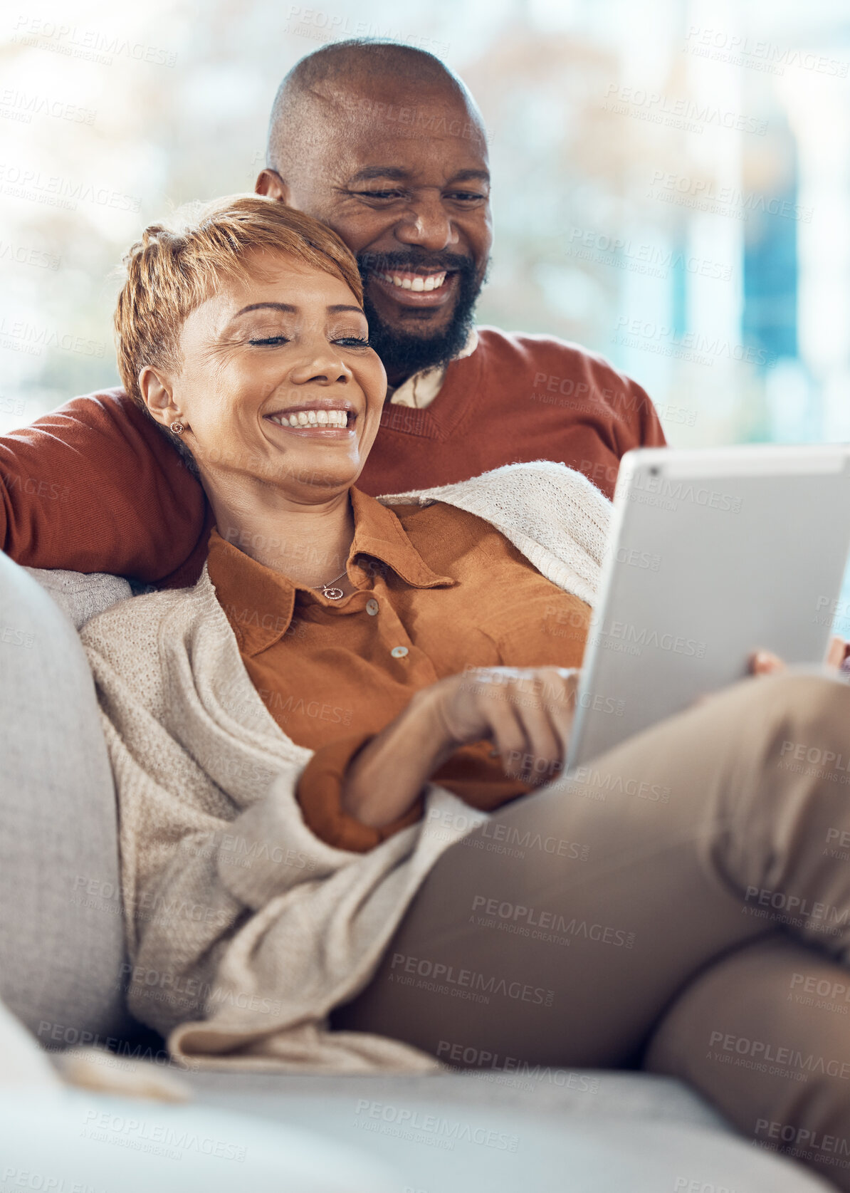 Buy stock photo Black couple, relax and smile with tablet for online entertainment together on the living room sofa at home. Happy man and woman relaxing in happiness for internet, connection and streaming on couch