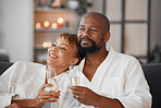 Spa, couple and romance with champagne relax, happy together and calm bonding on sofa. Married man, woman smile and relationship wellness therapy on romantic honeymoon or relaxing vacation travel 