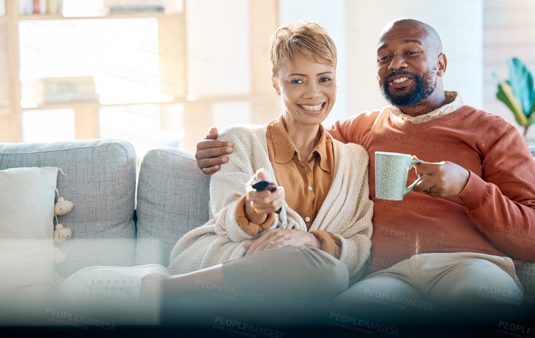Buy stock photo Watching tv, home and couple relax together on sofa or home living room for online show, movie or comedy. Love, care and black woman, man or happy people streaming film on television for quality time