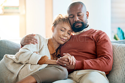 Buy stock photo Love, relax and trust with a black couple on a sofa in the living room of their home together. Hug, marriage and romance with a mature man and woman bonding in the lounge of a house for calm peace