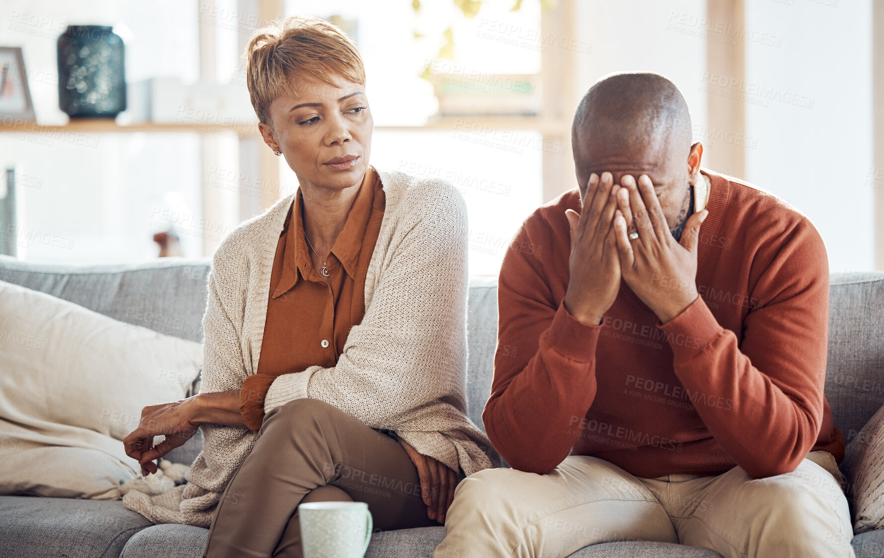 Buy stock photo Divorce, stress and mature couple arguing on the sofa in the living room of their house. Frustrated, relationship problems and upset African man and woman speaking in the lounge of their home.