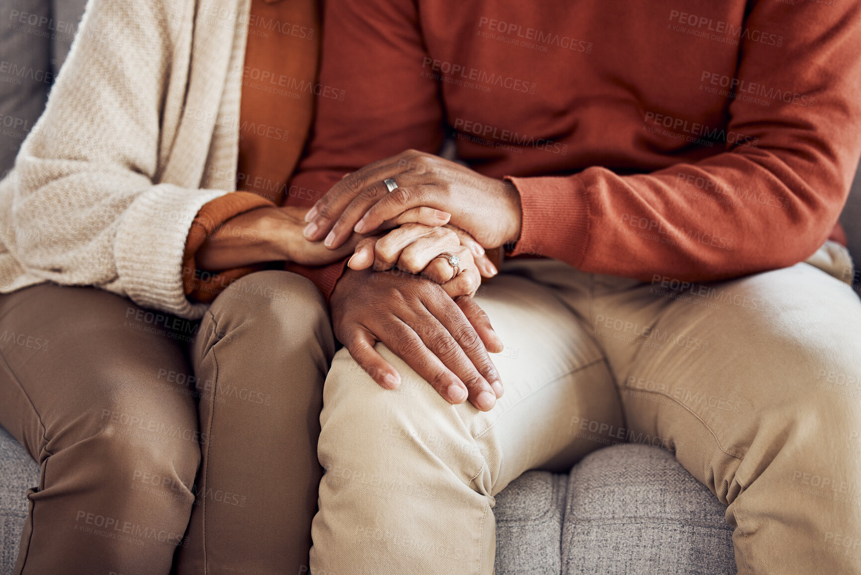 Buy stock photo Black couple, holding hands on sofa or comfort support, care and love bonding together in home living room. Black man, black woman sitting couch and embrace with kindness, trust and help with problem