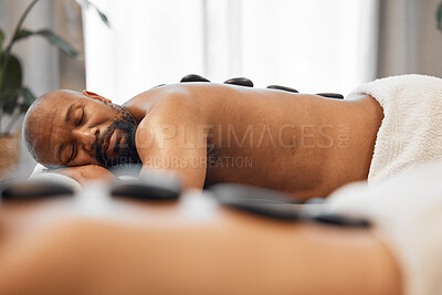 Buy stock photo Relax, hot stone massage and mature couple together in luxury hotel spa or salon for romantic anniversary weekend. Health, wellness and romance, relaxing sleep for mature black man on summer vacation