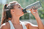 Fitness, woman and drinking water bottle after training workout, exercise and outdoor cardio running in Australia. Thirsty young athlete, sports hydration and nutrition for wellness, health and body 