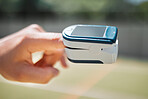 Hand, health and pulse oximeter in nature for oxygen measurement. Healthcare, wellness or SPO2 meter on finger of person to check, monitor or test blood levels or heart rate outdoors at park outside
