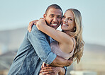 Happy interracial couple, hug and portrait smile for relationship happiness, travel or bonding in the outdoors. Man and woman hugging, smiling and enjoying time together for love, support and care