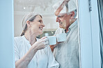 Love, coffee and window with senior couple relax, laugh and bond while looking cozy, happy and drinking coffee in their home. Glass, tea and elderly people enjoy retirement, quality time and rest