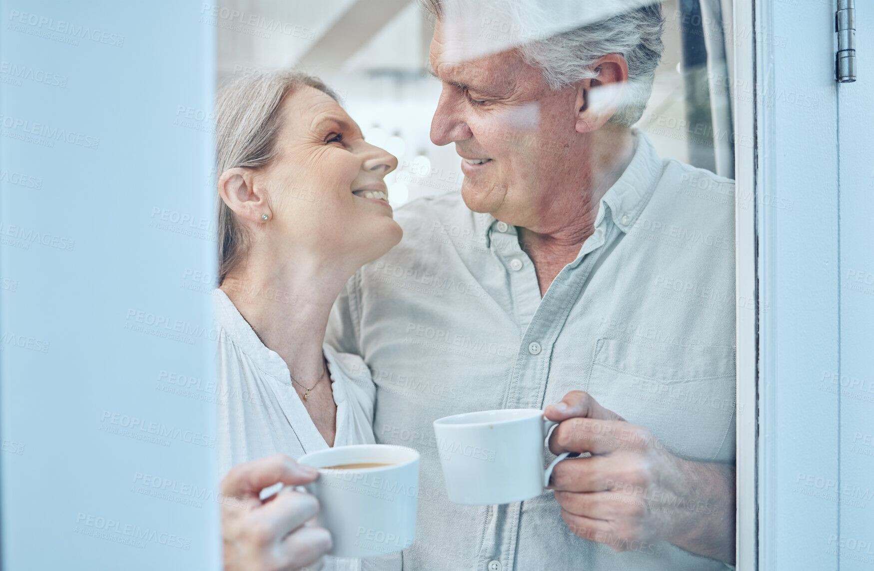 Buy stock photo Retirement, coffee and love with a senior couple drinking or enjoying a beverage together in their home. Relax, romance and bonding with an elderly man and woman pensioner by a door in their house