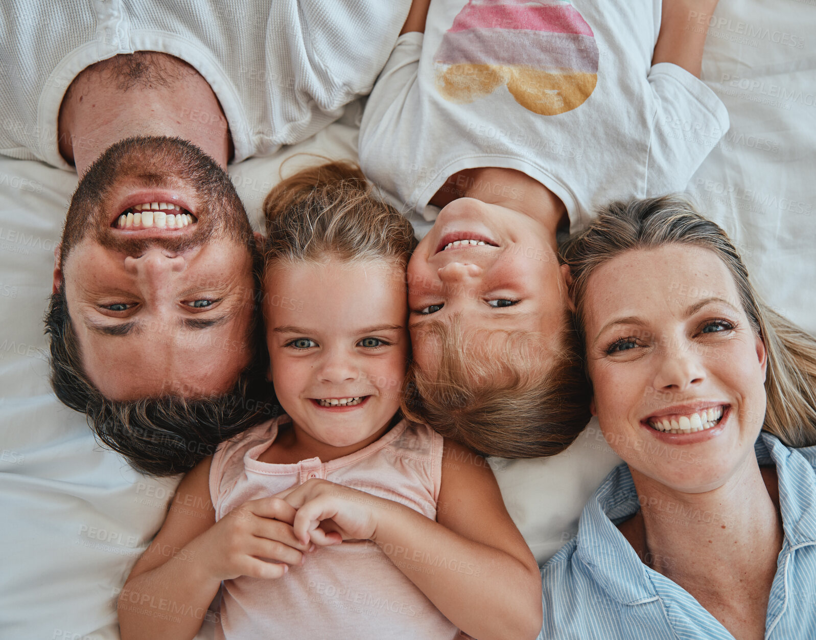 Buy stock photo Happy family, love and above morning smile with parents and children lying and happy in bedroom for fun together at home. Laugh and man and woman love, care and happiness with girl kids to bond
