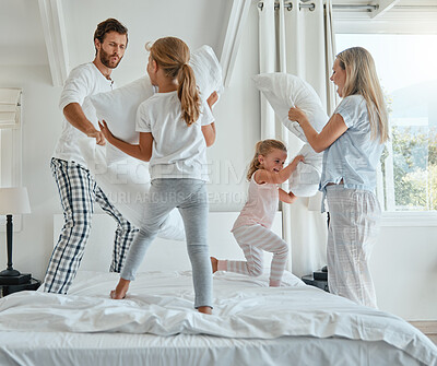 Buy stock photo Family, children and pillow fight with parents and girl siblings having fun playing in a bedroom together. Kids, happy and bonding with a man, woman and daughter sisters playful with pillows on bed