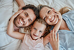 Happy, relax and portrait of family in bed with top view for wake up, support and smile together. Peace, bonding and connection with parents and girl lying at home for weekend, care and lifestyle