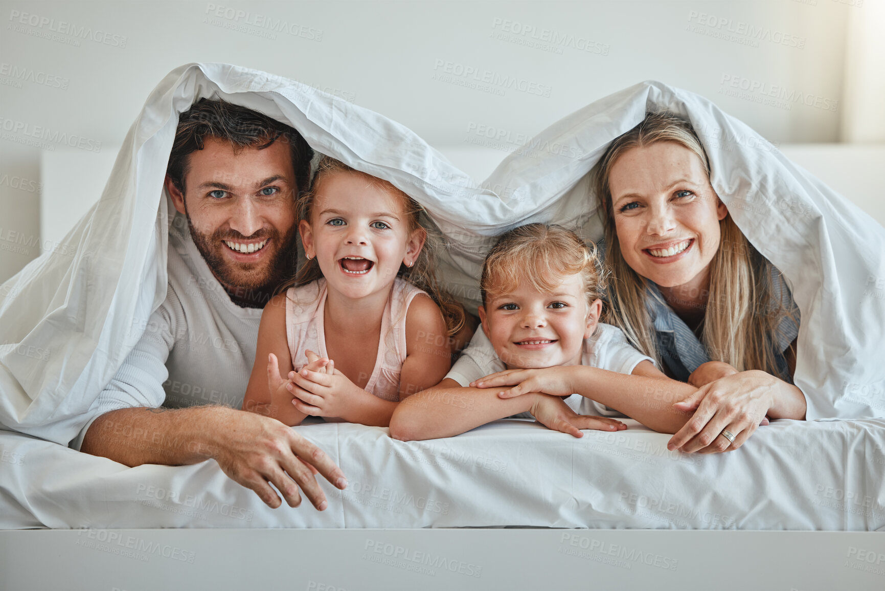 Buy stock photo Love, parents and kids under blanket, happy and laugh together for fun, smile and joy. Portrait, family, and have quality time on vacation, holiday and bonding in bedroom for the weekend and cheerful