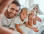 Selfie, family and bed with parents and children posing for a photograph together in the morning at home. Bedroom, love and picture with a mother, father and daughter siblings bonding in the bedroom