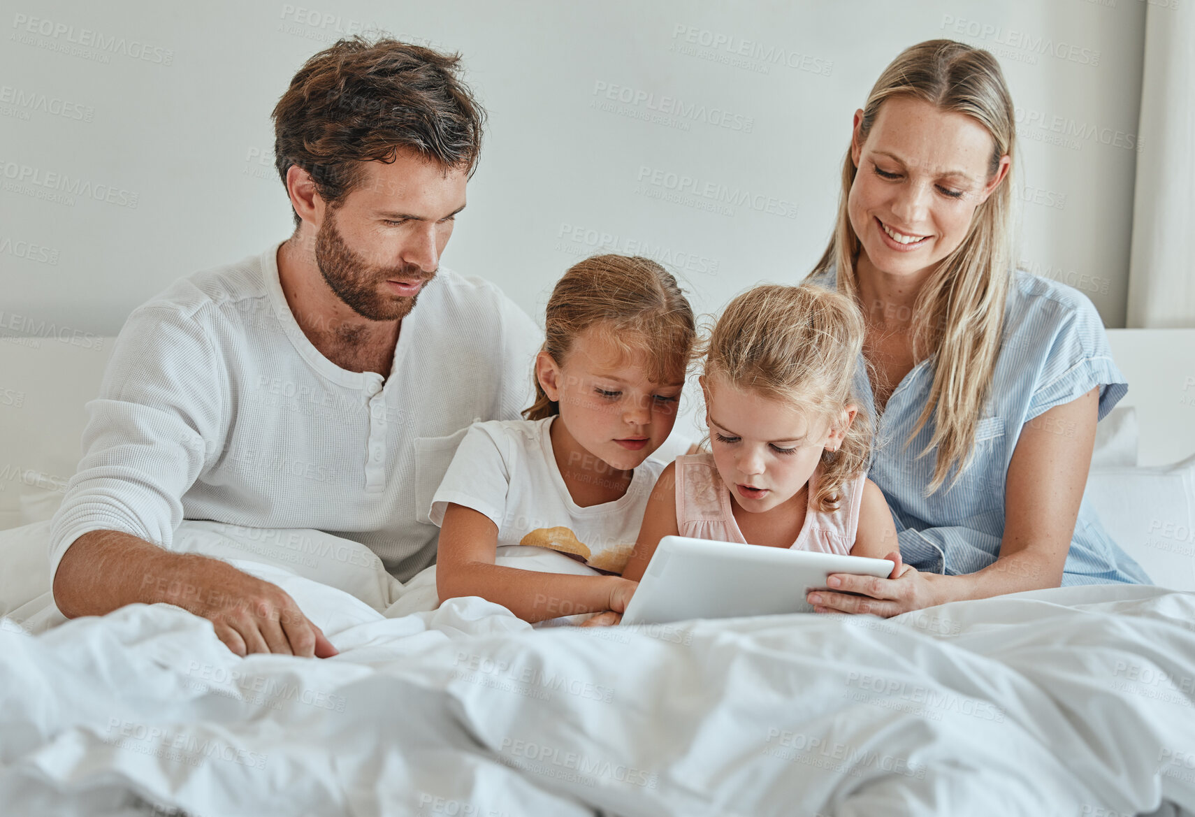 Buy stock photo Tablet, movie and family in bedroom streaming a lovely series on subscription online and relaxing on a lazy morning. Mother, father and children watching tv for bonding and entertainment on a weekend