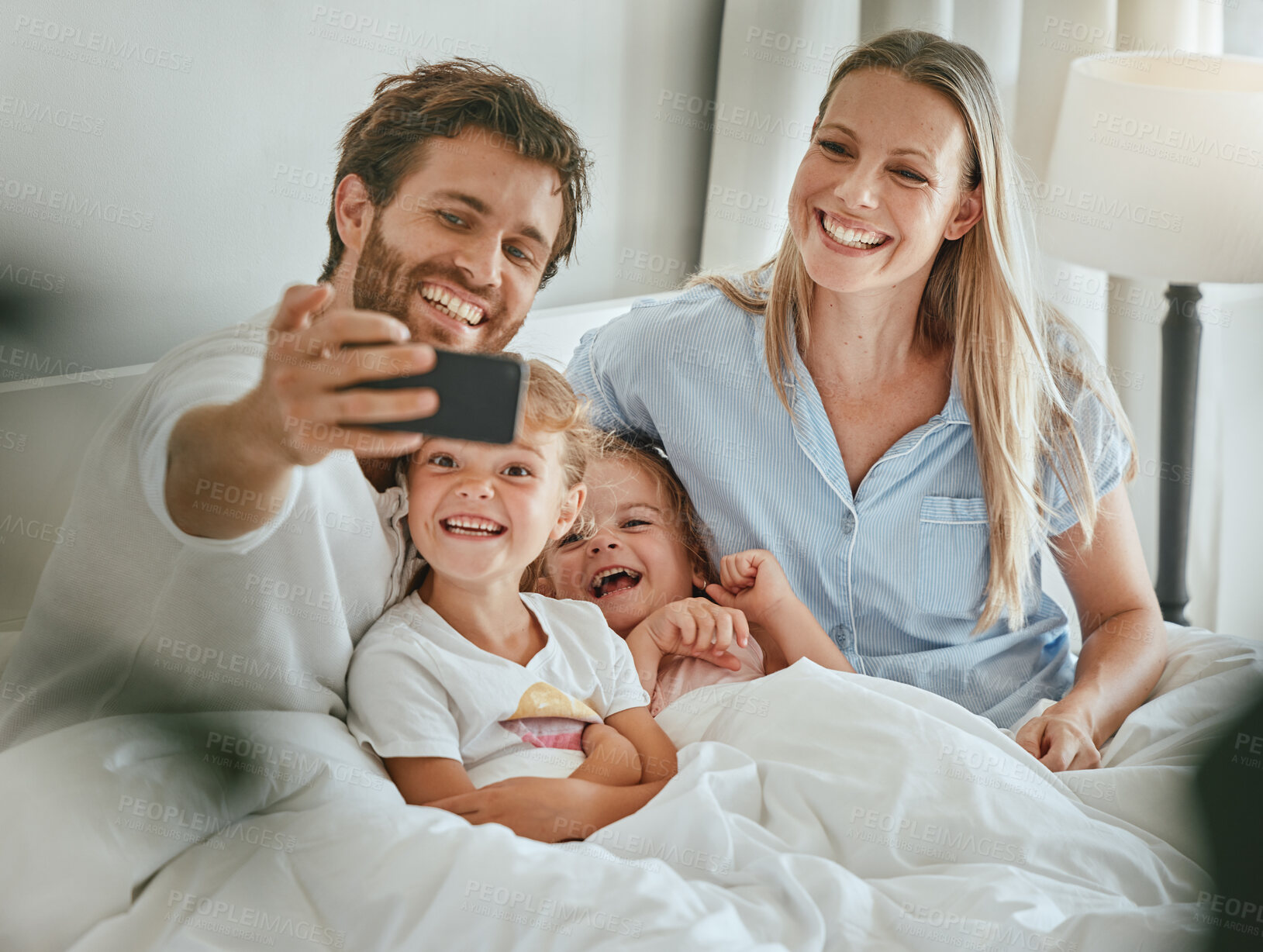 Buy stock photo Phone selfie, family and relax in bed together bonding, smiling for mobile photograph for social media. Happy parents, excited smiling children and digital tech smartphone in bedroom at home