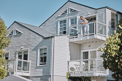 Buy stock photo Real estate, house and couple relax on balcony of their dream home, happy, proud and laughing. Property, family and happy man, woman and homeowners enjoy conversation, joke and terrace view together