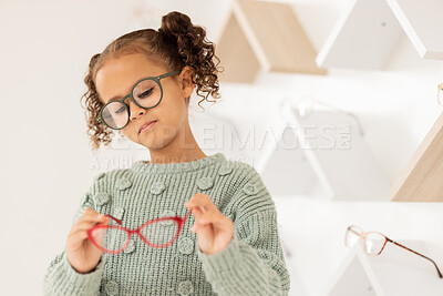 Buy stock photo Glasses, options and children with a girl in an optometry store while shopping for prescription lenses. Kids, retail and vision with a female child customer looking at eyewear at the optometrist