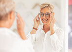Senior woman, smile and mirror for glasses, vision or eyesight at optometry store. Happy elderly female smiling in happiness for new spectacles looking at reflection in eye care at the optometrist