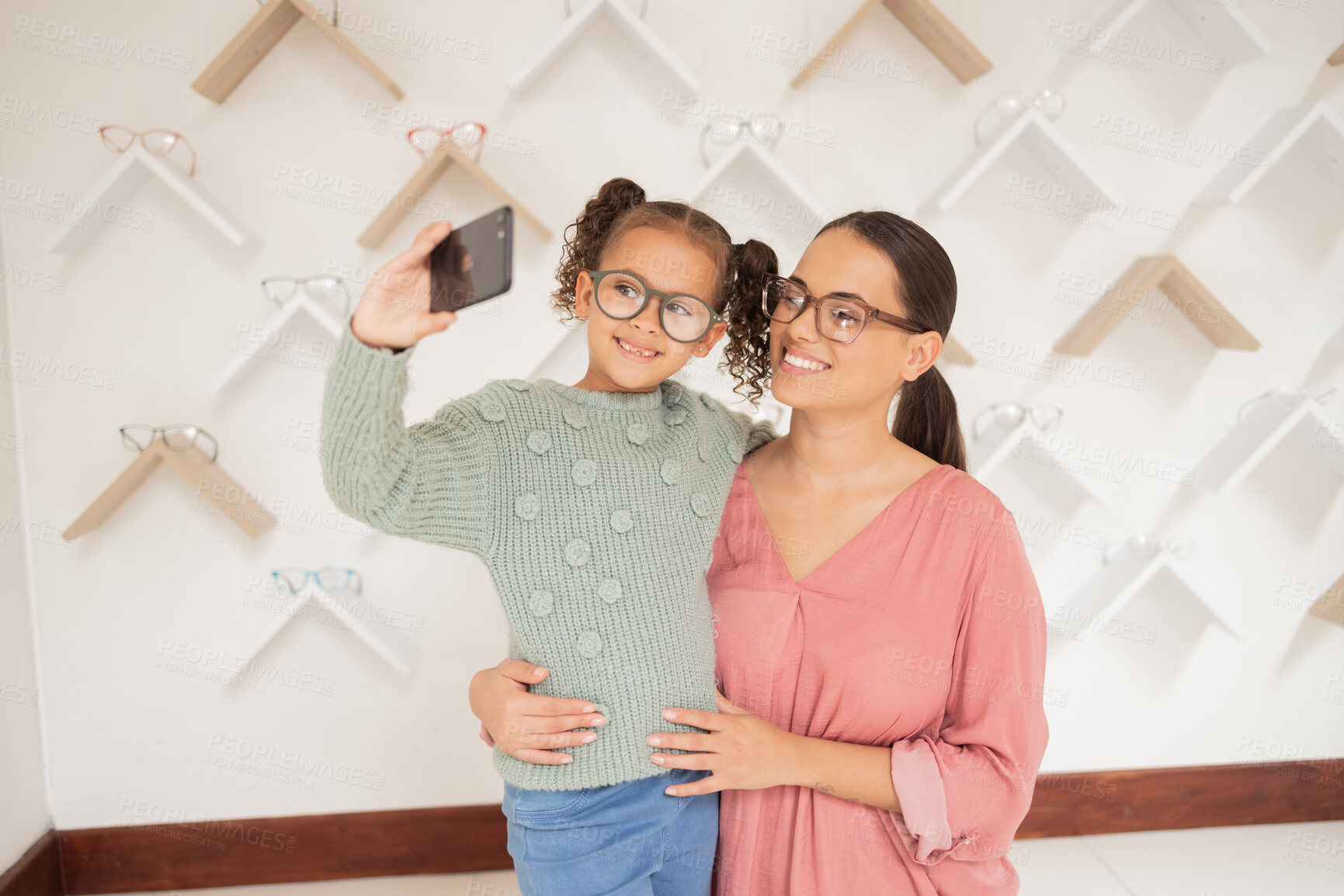 Buy stock photo Selfie, phone and family with vision glasses at retail shop for wellness, eye care and health. Mother, child and smile for smartphone social media photograph together in expert optometry shop.