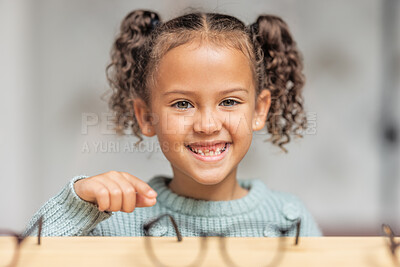 Buy stock photo Optics store, child and smile for glasses choice for eye care, vision and focus while shopping for lens frame and pointing. Portrait, face and smile of girl customer making decision in optometry shop