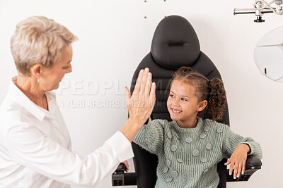 Buy stock photo High five, optometrist and children with a girl and woman in an optometry appointment for prescription lenses. Motivation, eye test and success with a female child and optician in celebration