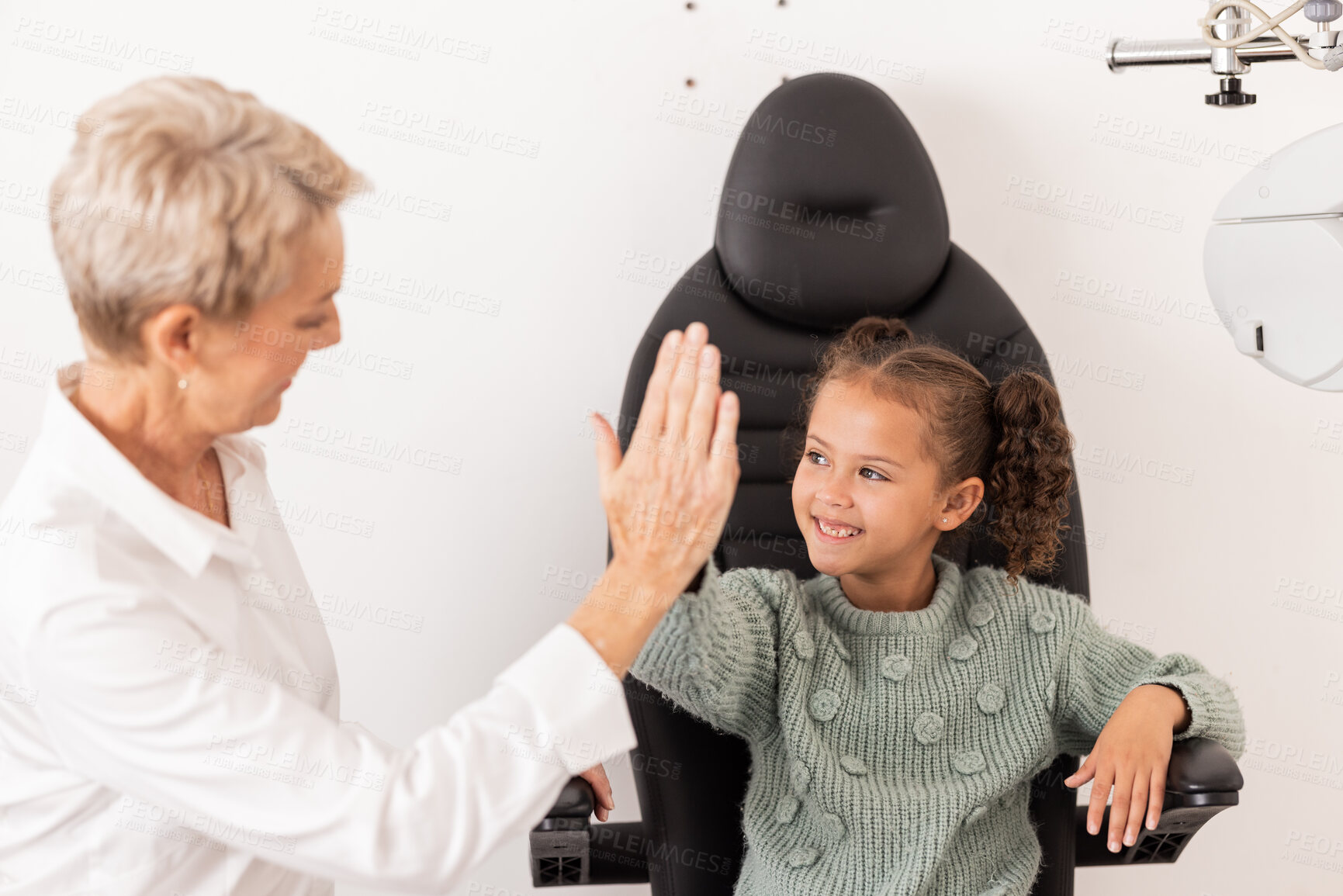 Buy stock photo High five, optometrist and children with a girl and woman in an optometry appointment for prescription lenses. Motivation, eye test and success with a female child and optician in celebration