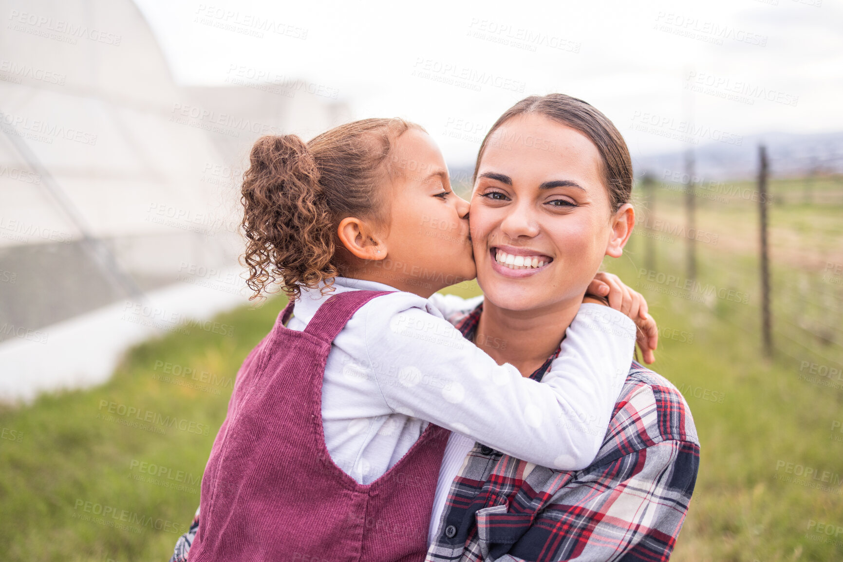 Buy stock photo Mother, kiss and girl on a sustainability, agriculture and ecology farm with family love and care. Portrait of a mama and kid on a eco friendly, clean energy and green farming countryside with smile