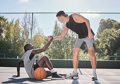 Buy stock photo Sports, teamwork and men with helping hand in basketball, player giving support, help and assistance. Fitness, friends and man lifting black man with injury from ground on outdoor basketball court