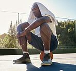 Basketball, fitness and rest with a black man in sports sitting on a ball at an outdoor court after a game. Workout, thinking and health with a male basketball player outside for exercise or training