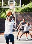 Basketball, sports and athlete scoring during game or training on an outdoor court in the city. Score, goal and man playing, practicing or doing an exercise for championship match on basketball court