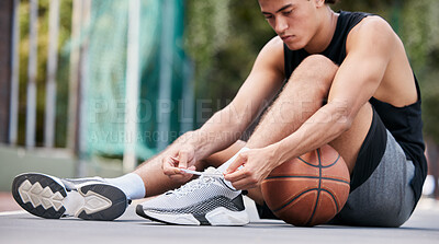 Buy stock photo Basketball player, shoes and sports in preparation for game, match or fitness on the court outdoors. Man on basketball court tying shoe laces getting ready or prepare for exercise or training workout