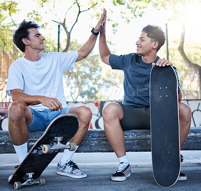Buy stock photo High five, skateboard and skater friends at city skatepark, young men sitting in park and celebration of achievement. Freedom, urban fun and happy gen z men hands celebrate skate trick goals