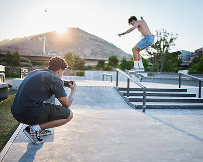 Buy stock photo Skateboard jump outdoor, photographer in park for extreme sports photoshoot with skater in summer. Skatepark photo session, man grind rail and sport for fitness, stunt and training in Cape Town