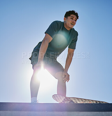 Buy stock photo Young man, skateboard and freedom on blue sky lens flare at urban skate park, city and relaxing summer for training, outdoor action and sports hobby in USA. Skater ready for action jump risk off ramp