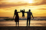 Beach silhouette, couple holding child and sunset ocean holiday by waves, sand and summer sun background. Scenic travel vacation, family by sea and swinging child together with love, care and freedom