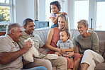 Kids, love and happy family on sofa with baby, laughing and playing in living room in their home. Interracial, happy family and grandparents, parents and children relax, bond and enjoy quality time