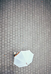 Top view, rain and person with umbrella in city, street or urban road mock up. Travel, freedom and pedestrian with parasol on asphalt in winter weather traveling, standing or enjoying time outdoors