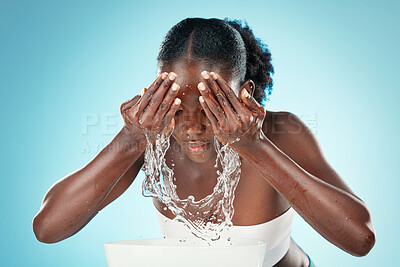 Buy stock photo Woman, water splash and face cleaning, wellness and body hygiene for glowing skincare on studio blue background. Black model, facial beauty and water drop to washing face, fresh routine and self care