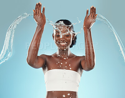 Buy stock photo Water, splash and black woman washing on a blue studio background for hygiene and grooming. Clean, cleansing and bodycare or skincare for african american female showering for beauty and wellness