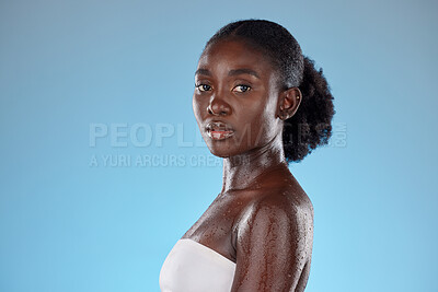 Buy stock photo Face, beauty and skincare with a model black woman wet in studio on a blie background with mockup. Portrait, wellness and luxury with an attractive young female posing to promote hydration or health