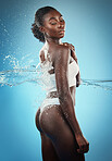 Black woman, water splash and body shower, cleaning and skincare for clean body, hygiene and wellness. Relax, luxury and wellness with an attractive young female posing in a bathroom or beauty wash