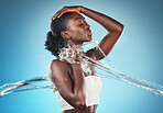 water splash, black woman and skincare health shower for cosmetic beauty, wellness and body cleaning. African american girl, luxury dermatology lifestyle and body care in blue background studio