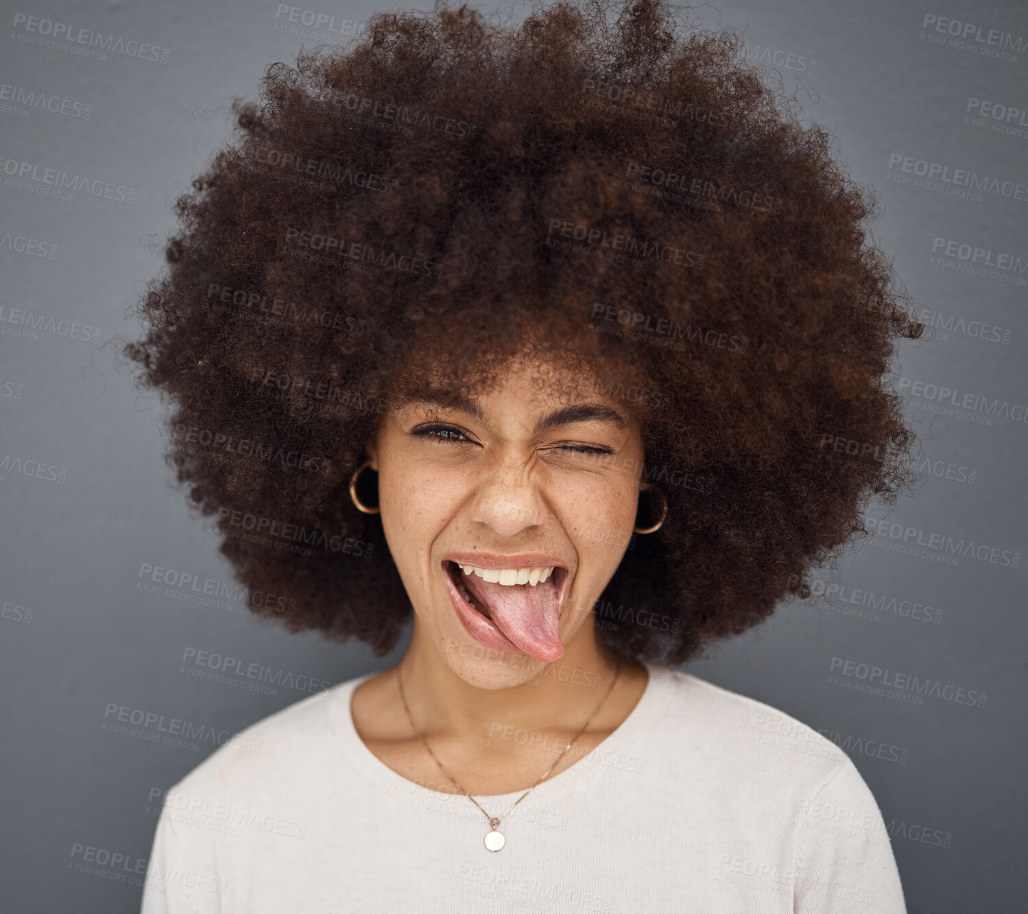 Buy stock photo Goofy, face and woman with her tongue out in studio with comic, fun and crazy facial expression. Silly, funny and portrait of happy girl model from Puerto Rico standing and posing by gray background.