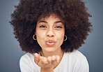 Face, portrait and woman blowing a kiss on a grey studio background being flirty and seductive. Fun, flirting and beautiful african american female kissing and being alluring and isolated on backdrop