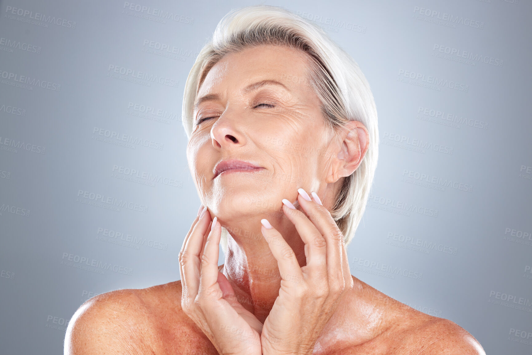 Buy stock photo Senior woman, relax and beauty for skincare, cosmetic or facial treatment against a grey studio background. Happy elderly female hands touching face in satisfaction for perfect skin, glow or makeup
