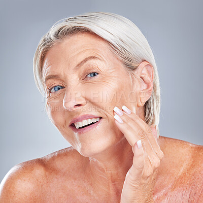 Buy stock photo Skincare, wellness and senior woman with face for inspection, health and beauty against a grey studio background. Happy, smile and portrait of an elderly person with facial care during retirement
