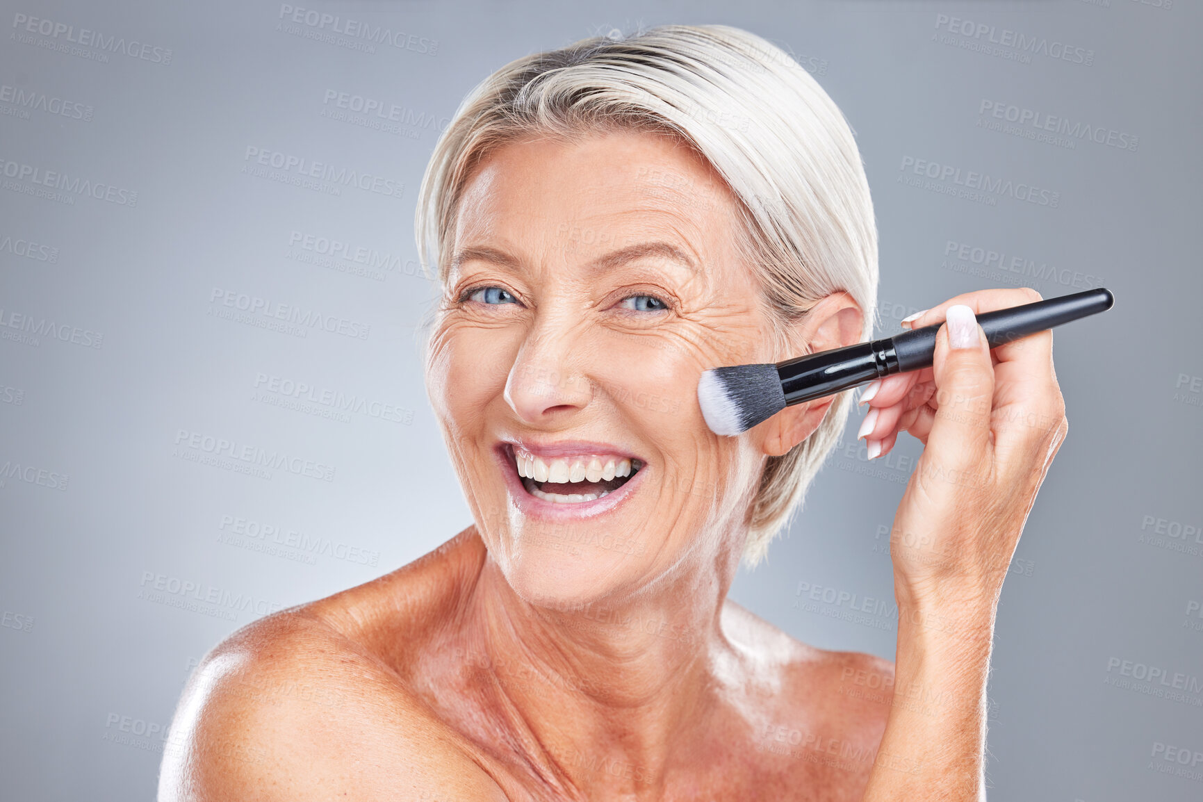 Buy stock photo Senior woman, face makeup and beauty with brush to apply skincare, anti aging or facial cosmetics product. Wellness, self care and happy elderly female smile, health and makeup brush for foundation