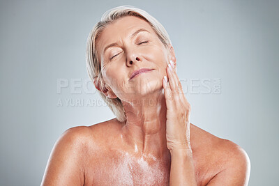 Buy stock photo Senior woman, relax and skincare beauty for cosmetics, moisturizer or treatment against a grey studio background. Elderly female hand touching face in satisfaction for perfect skin or facial care