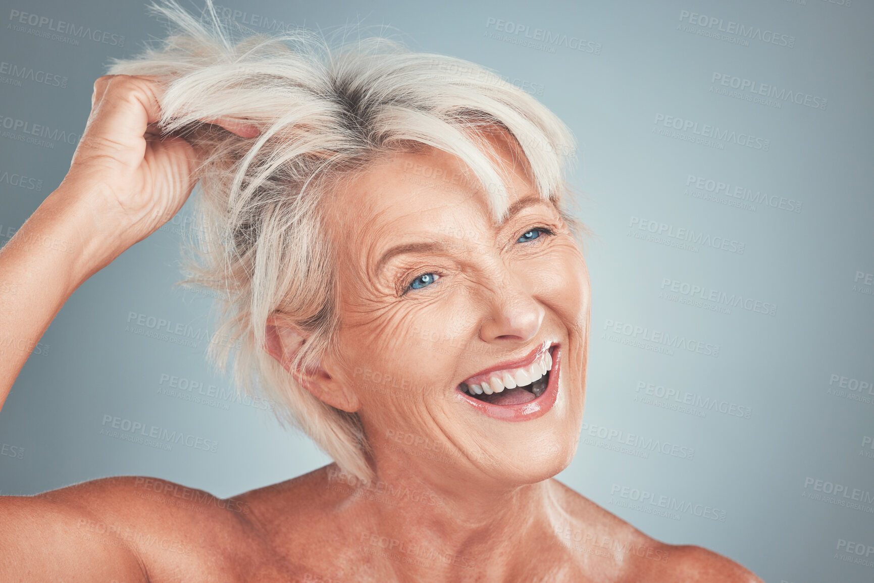 Buy stock photo Happy, hair and senior woman in a studio for beauty, hair care and cosmetics for a hair style. Happiness, smile and beautiful elderly female model with natural makeup isolated by a gray background.