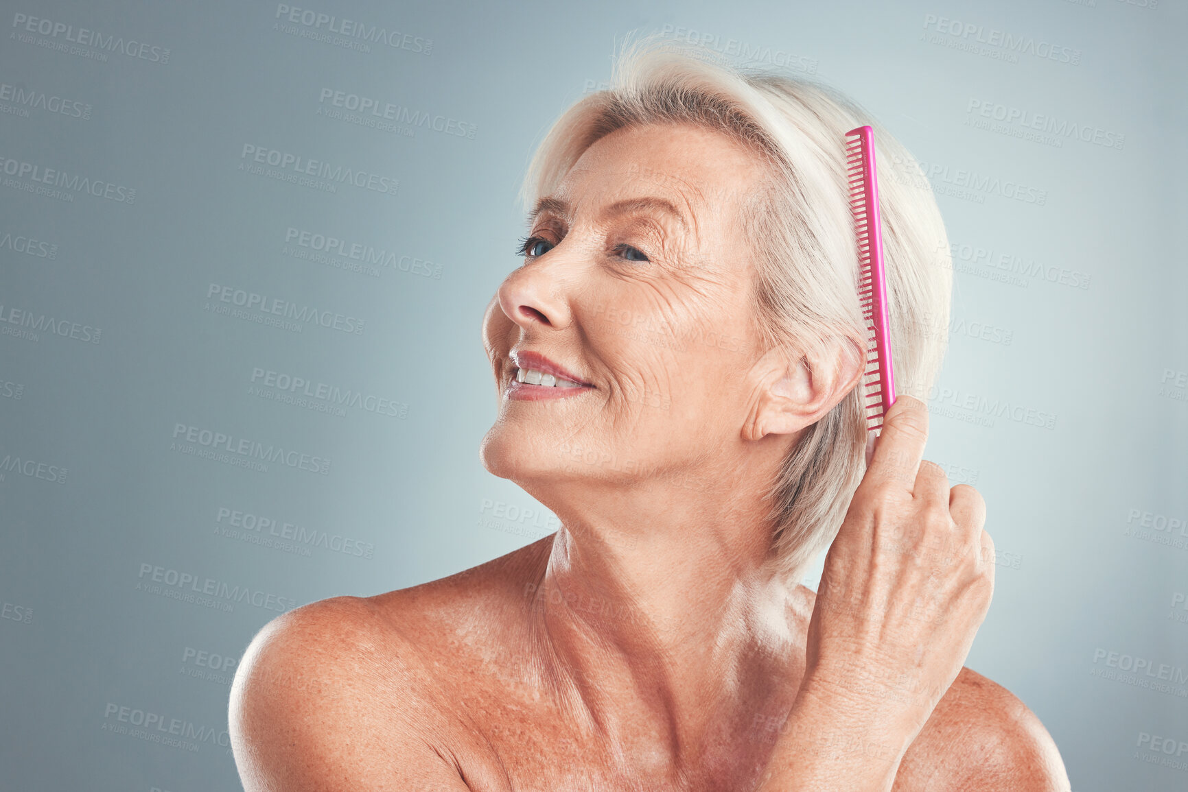 Buy stock photo Hair, beauty and senior woman brushing hair, grooming and in studio for wellness, routine and self care on grey background. Grey hair, elderly model and comb by lady styling, relax and hygiene care